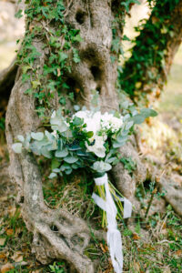 Il bouquet della sposa di rose bianche, rami di eucalipto, aronia e nastri bianchi